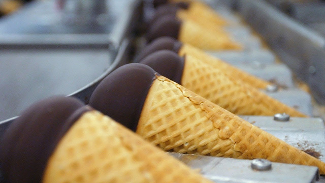 Ice cream cone production line with chocolate-coated cones on a conveyor